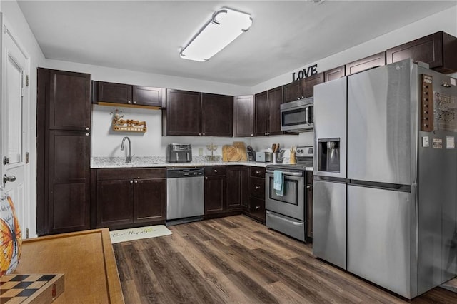 kitchen with dark wood-type flooring, dark brown cabinetry, appliances with stainless steel finishes, and sink