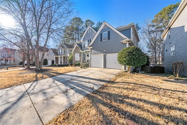 view of front of home featuring an attached garage, a residential view, and concrete driveway