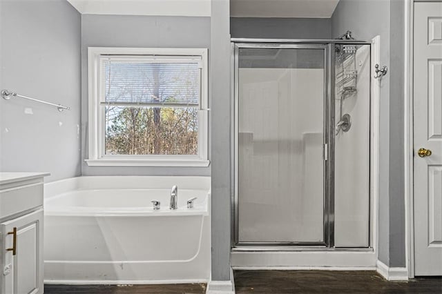 bathroom with a garden tub, a shower stall, vanity, and wood finished floors