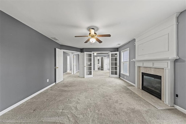 unfurnished living room featuring carpet floors, french doors, a fireplace, visible vents, and baseboards