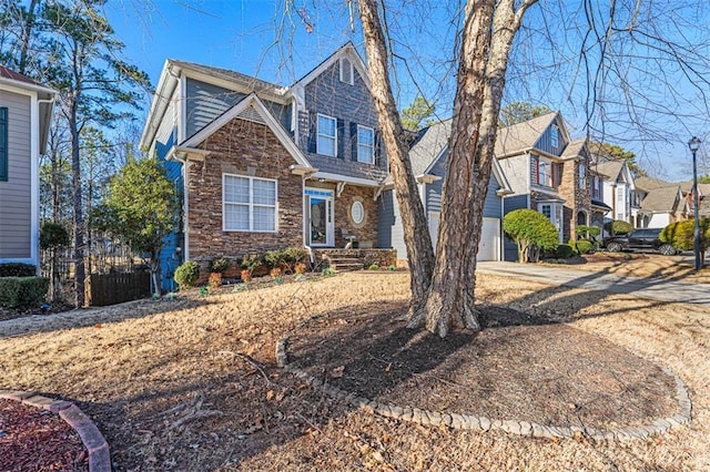 view of front of home with a garage, stone siding, a residential view, and driveway