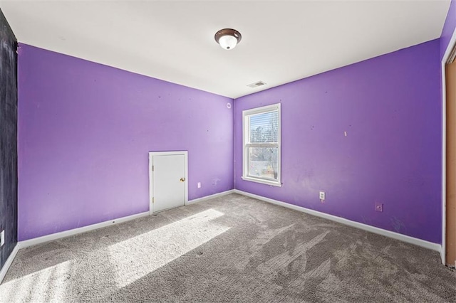 unfurnished room featuring carpet, visible vents, and baseboards