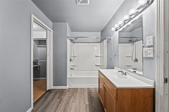 bathroom featuring shower / bath combination, wood finished floors, vanity, visible vents, and baseboards