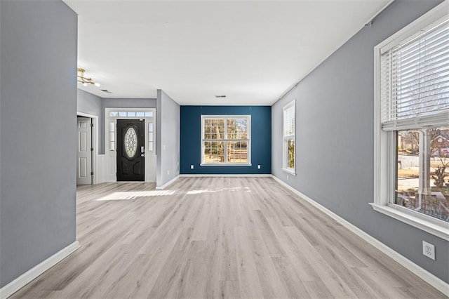 unfurnished living room featuring wood finished floors and baseboards