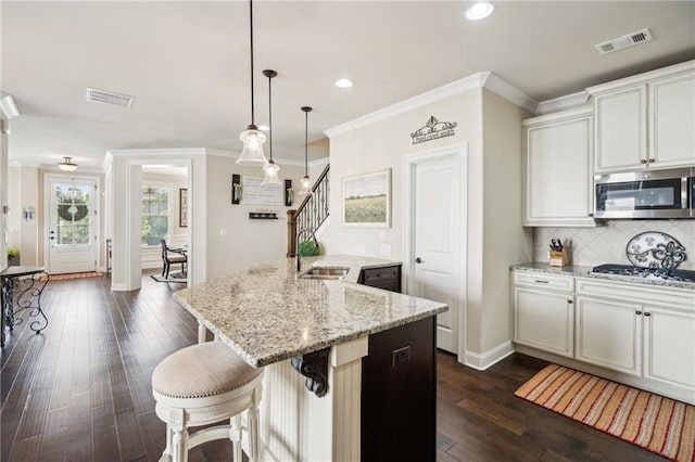 4155 Brookview Dr, Cumming, GA 30040 - kitchen with stainless steel appliances, a sink, ornamental molding, decorative backsplash, and a center island with sink