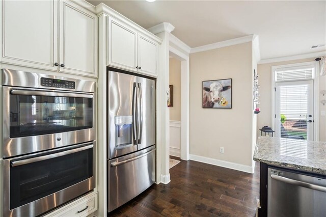4155 Brookview Dr, Cumming, GA 30040 - kitchen featuring appliances with stainless steel finishes, ornamental molding, dark wood-style flooring, light stone countertops, and white cabinets
