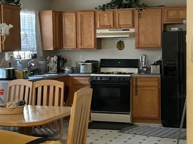 kitchen featuring black fridge with ice dispenser and white range with gas cooktop