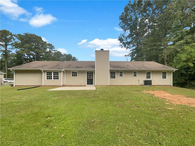 back of property featuring a patio, a lawn, central AC, and a chimney