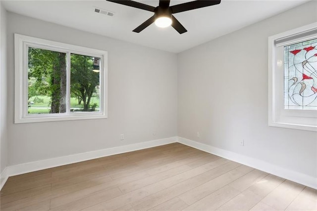 unfurnished room featuring a ceiling fan, baseboards, visible vents, and light wood-type flooring