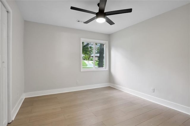 empty room featuring baseboards, light wood-style flooring, and ceiling fan