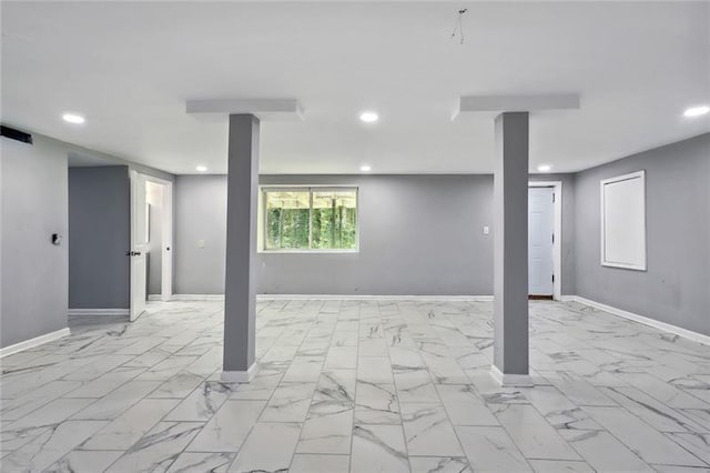 below grade area featuring baseboards, visible vents, recessed lighting, and marble finish floor