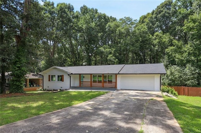 ranch-style home featuring a garage, fence, driveway, and a front yard