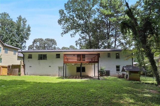 rear view of property with a yard, an outbuilding, a storage shed, and a wooden deck