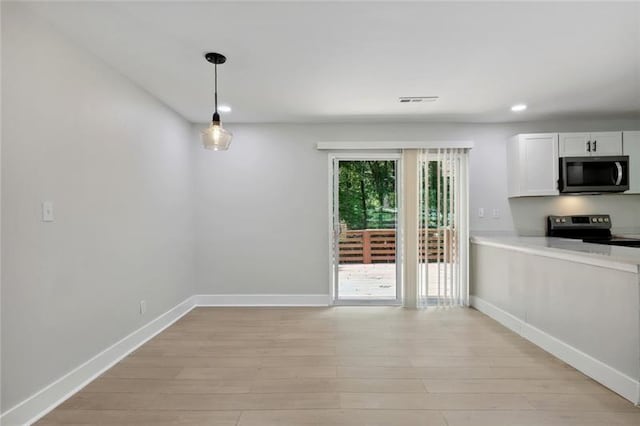 unfurnished dining area featuring baseboards, recessed lighting, light wood-style flooring, and visible vents