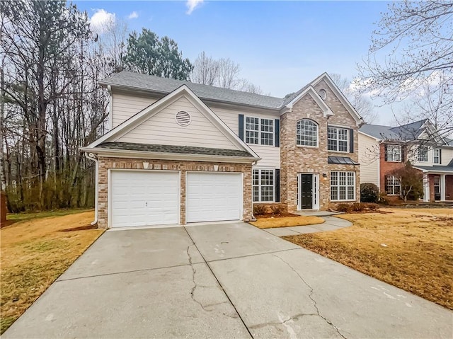 traditional-style home featuring a garage, concrete driveway, brick siding, and roof with shingles