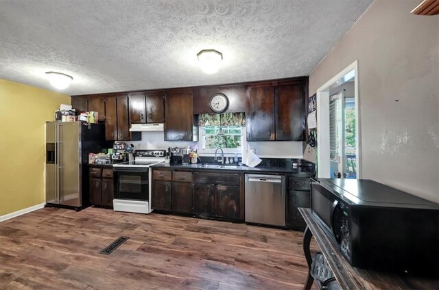 kitchen featuring hardwood / wood-style flooring, dark brown cabinetry, and appliances with stainless steel finishes