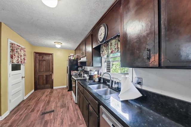 kitchen with dark hardwood / wood-style flooring, sink, dark brown cabinets, and appliances with stainless steel finishes