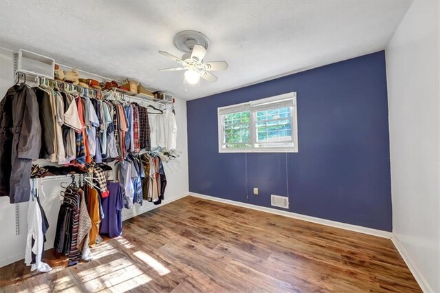 walk in closet with ceiling fan and wood-type flooring