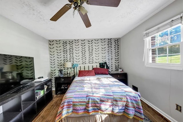 bedroom featuring a textured ceiling, dark hardwood / wood-style floors, and ceiling fan