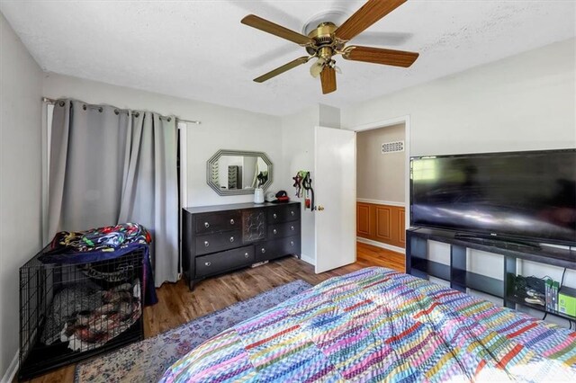 bedroom with dark hardwood / wood-style flooring and ceiling fan