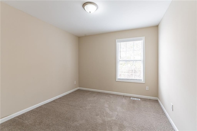 carpeted spare room with baseboards and visible vents