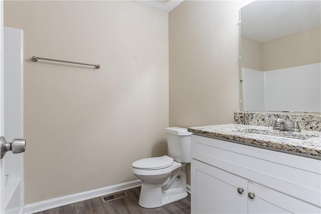 full bath with toilet, vanity, wood finished floors, and visible vents