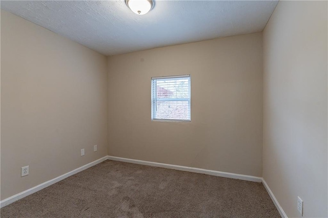 unfurnished room featuring carpet and baseboards