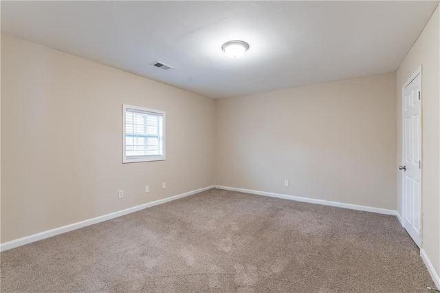 empty room featuring carpet flooring, visible vents, and baseboards