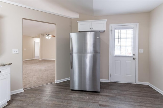 kitchen with dark wood-style flooring, freestanding refrigerator, open floor plan, white cabinetry, and light stone countertops