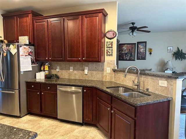 kitchen featuring ceiling fan, sink, kitchen peninsula, backsplash, and stainless steel appliances