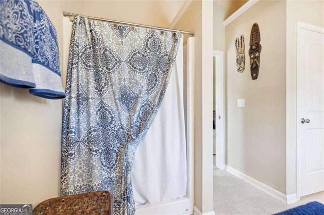 bathroom with crown molding and a shower with curtain