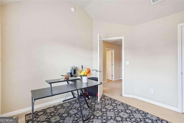 carpeted home office featuring vaulted ceiling