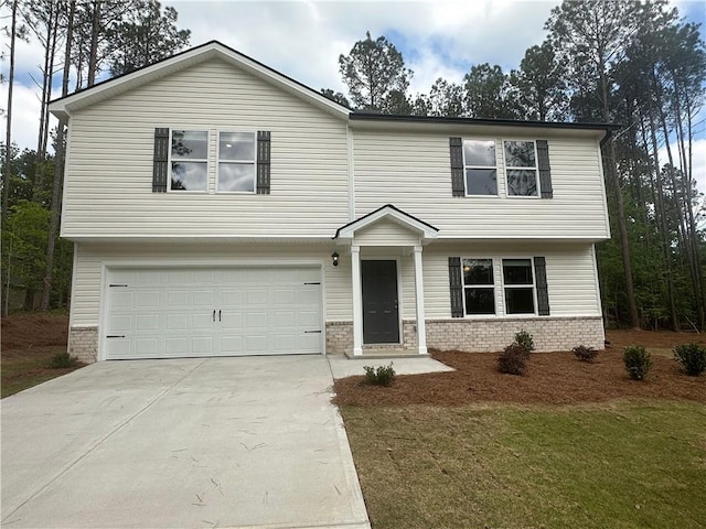 view of front of home with a garage, concrete driveway, and a front lawn