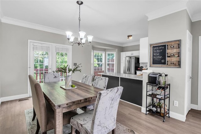 5990 Eagle Tiff Ln, Sugar Hill, GA 30518 - dining space with ornamental molding, a chandelier, and light wood-style floors