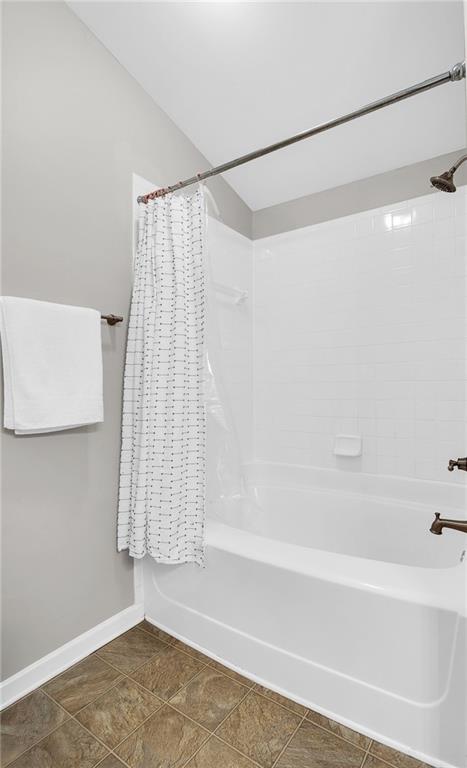 5990 Eagle Tiff Ln, Sugar Hill, GA 30518 - bathroom with shower / bath combo and baseboards