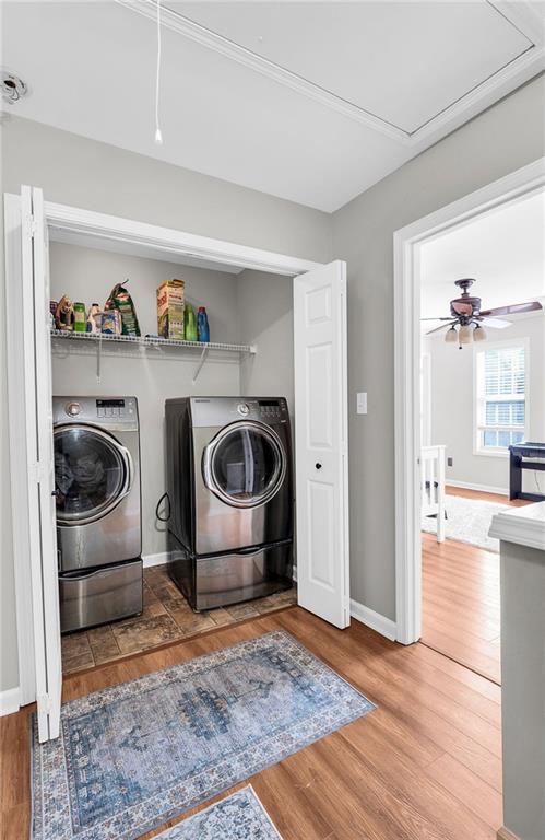 5990 Eagle Tiff Ln, Sugar Hill, GA 30518 - laundry room featuring washing machine and dryer, attic access, and wood finished floors
