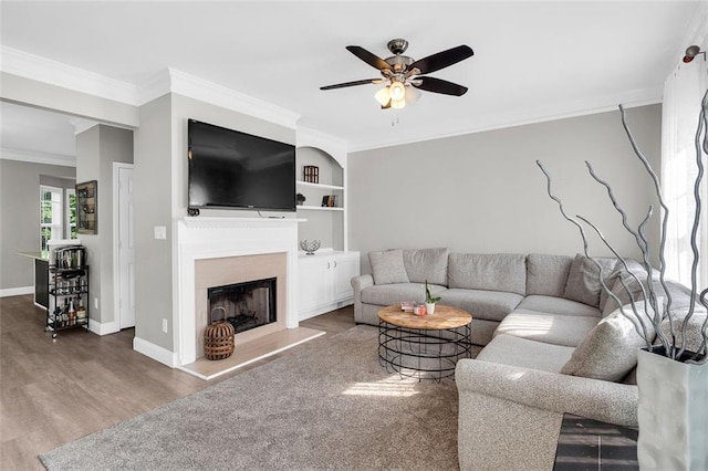 5990 Eagle Tiff Ln, Sugar Hill, GA 30518 - living area with a ceiling fan, wood finished floors, ornamental molding, a fireplace with raised hearth, and built in features