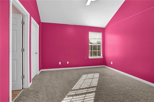 empty room with vaulted ceiling and carpet flooring