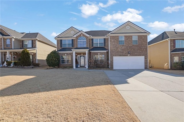 traditional-style house with a garage, concrete driveway, and brick siding