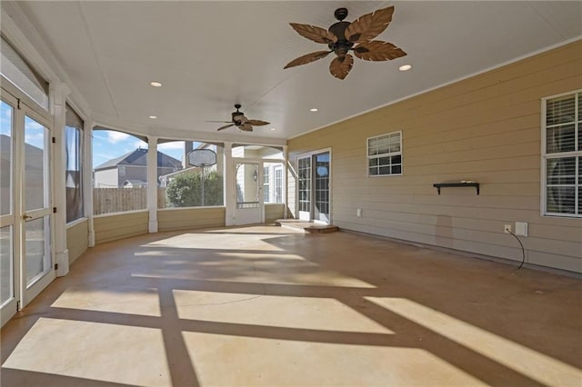 unfurnished sunroom with ceiling fan