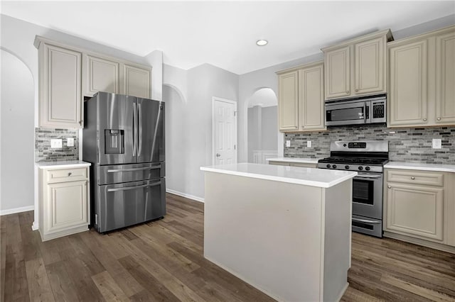 kitchen featuring hardwood / wood-style floors, stainless steel appliances, cream cabinetry, and a center island