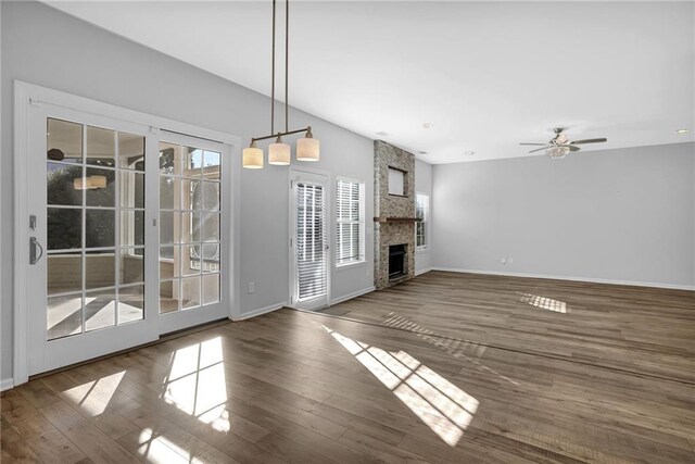 unfurnished living room featuring dark wood-type flooring, ceiling fan, and a fireplace