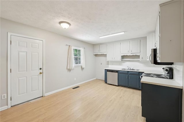 3388 Hamilton Mill Rd, Buford, GA 30519 - kitchen featuring appliances with stainless steel finishes, light wood finished floors, blue cabinets, light countertops, and a textured ceiling