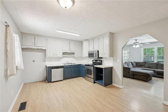 3388 Hamilton Mill Rd, Buford, GA 30519 - kitchen featuring appliances with stainless steel finishes, a sink, light wood finished floors, ceiling fan, and a textured ceiling