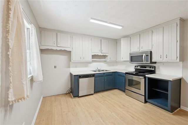 3388 Hamilton Mill Rd, Buford, GA 30519 - kitchen with stainless steel appliances, light wood-type flooring, blue cabinetry, baseboards, and a sink