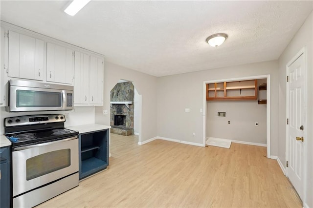 3388 Hamilton Mill Rd, Buford, GA 30519 - kitchen featuring appliances with stainless steel finishes, light countertops, light wood-style flooring, white cabinets, and open shelves