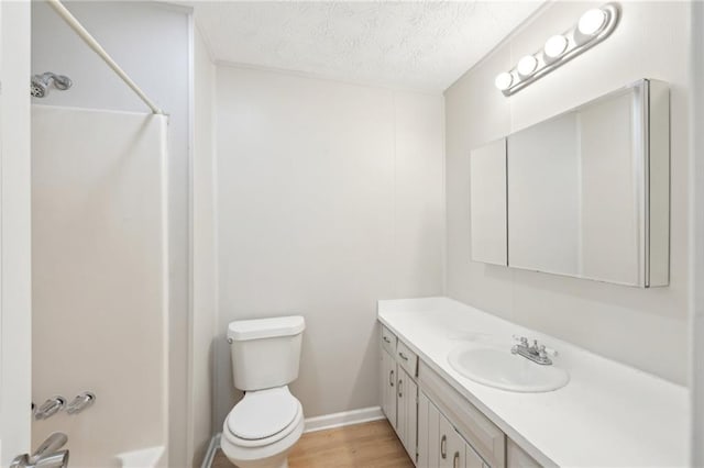 3388 Hamilton Mill Rd, Buford, GA 30519 - bathroom with vanity, toilet, a textured ceiling, wood finished floors, and baseboards