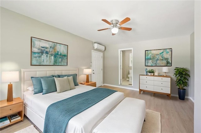 3388 Hamilton Mill Rd, Buford, GA 30519 - bedroom with an AC wall unit, light wood-type flooring, baseboards, connected bathroom, and a ceiling fan