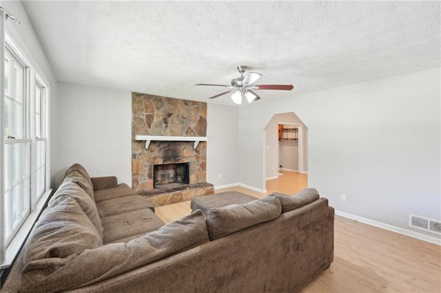 3388 Hamilton Mill Rd, Buford, GA 30519 - living room with a ceiling fan, light wood-style flooring, a textured ceiling, baseboards, and arched walkways