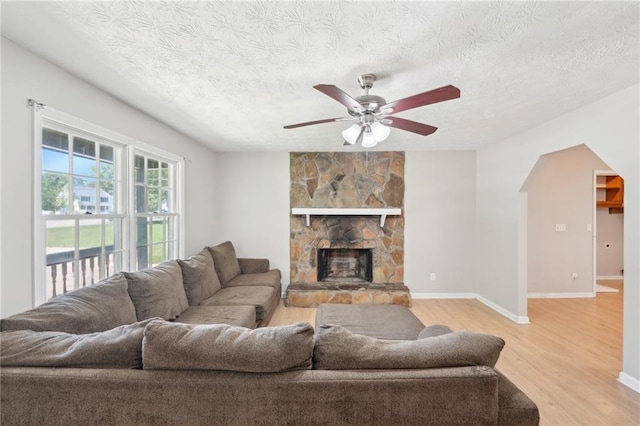 3388 Hamilton Mill Rd, Buford, GA 30519 - living room featuring light wood finished floors, a ceiling fan, a textured ceiling, baseboards, and a fireplace